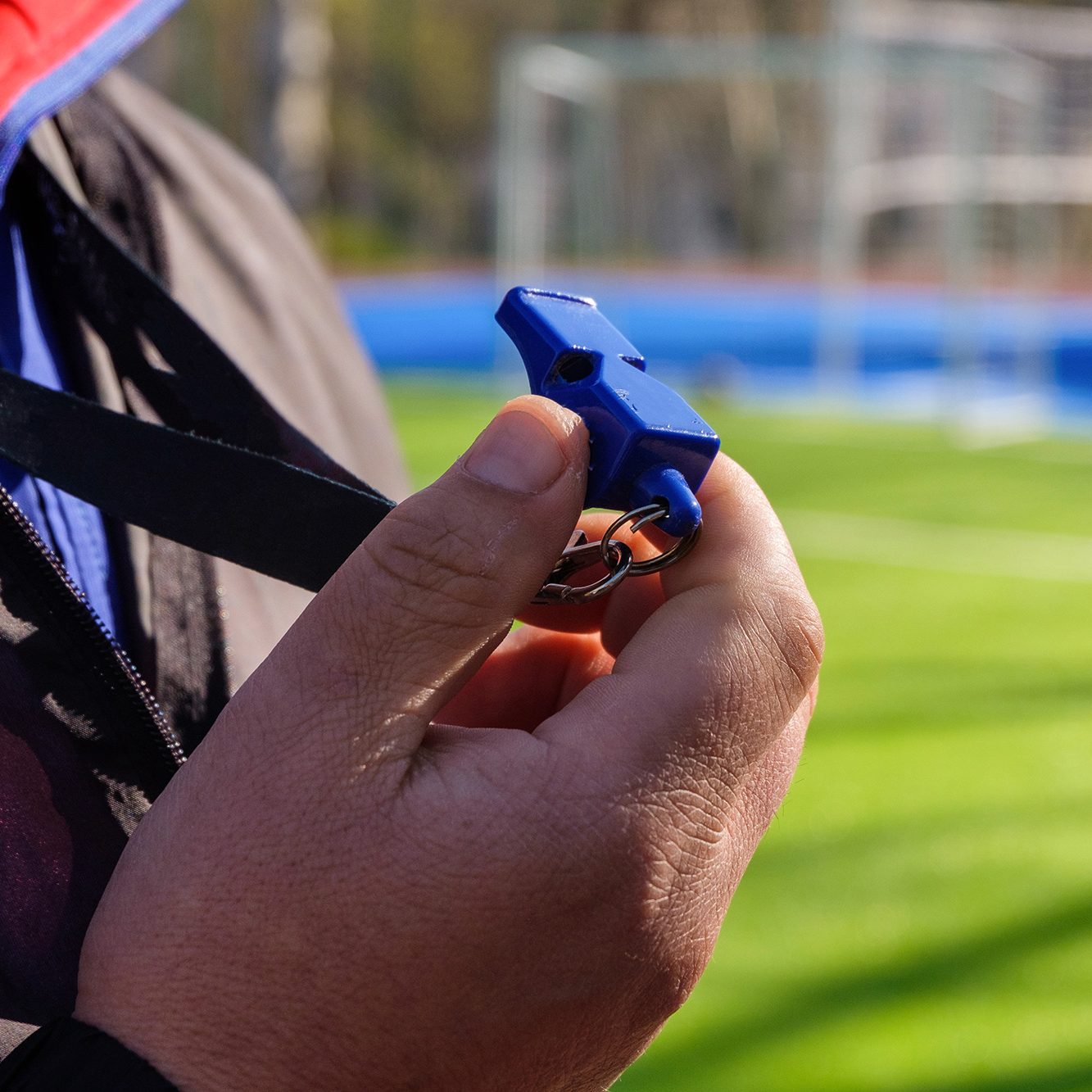 Referee holding a whistle on the sideline